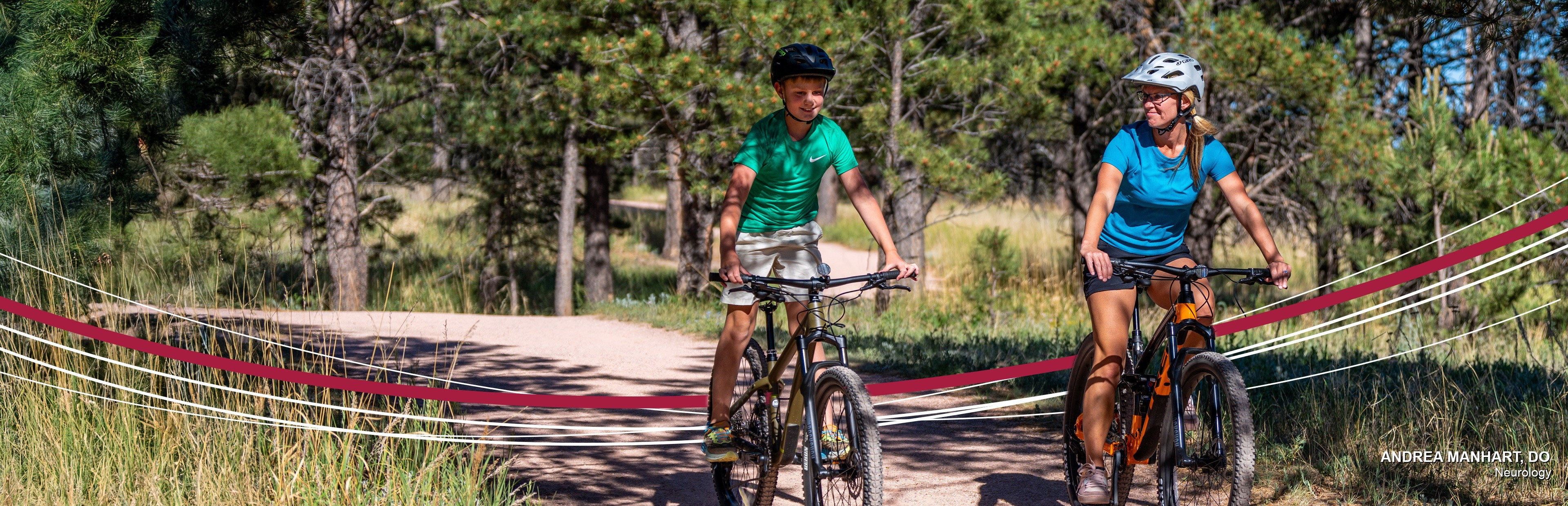 A parent and their child riding bikes on a forest trail